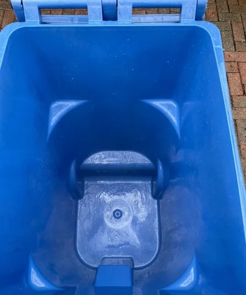 Sparkling clean blue recycling bin after professional cleaning